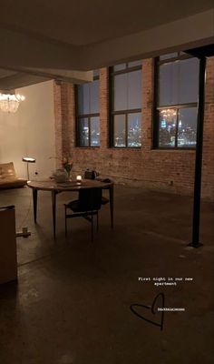 an empty room with chairs and tables in front of large windows at night, overlooking the city lights