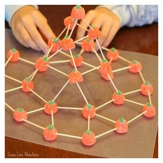 a close up of a child working on a string structure made out of gummy bears