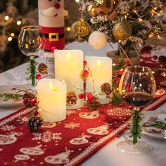 lit candles on a table with christmas decorations