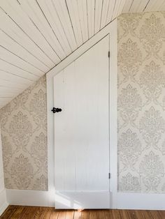 an empty room with wooden floors and wallpaper on the walls is pictured in this image