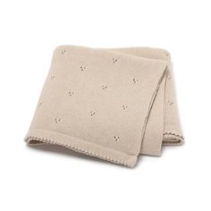 a knitted blanket with holes on the side and a crochet pattern in beige