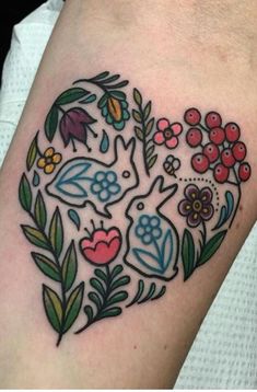 a tattoo with flowers and birds on it