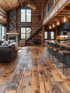 a living room filled with furniture next to a kitchen and dining area in a log cabin