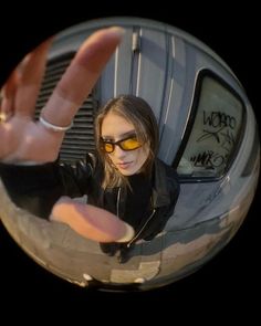 a woman wearing sunglasses is making a hand gesture