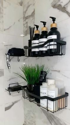 two black shelves with soaps, lotion and plants on them in a bathroom