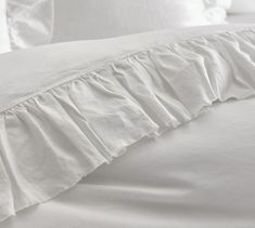 white bedding with ruffled edges and pillows