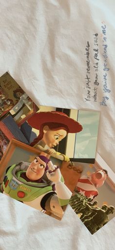 there are pictures of toy story characters on the bed sheet and in front of an envelope