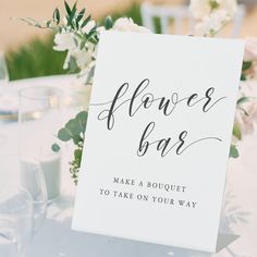 a sign that says flower bar sitting on top of a table