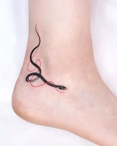 a woman's foot with a black and red tattoo design on the bottom of it