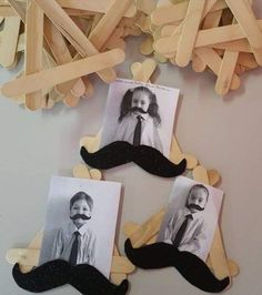 three pictures of two children with mustaches hanging from clothes pins on a white wall