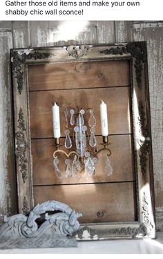 an old wooden frame with two candle holders and some glass beads hanging on the wall