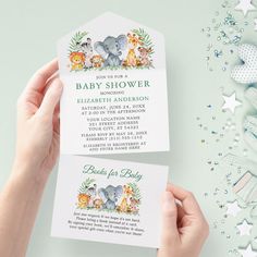 someone holding up two baby shower cards on top of a blue background with stars and confetti