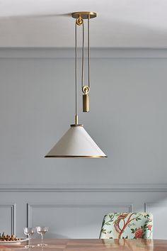 a dining room table with two chairs and a hanging light