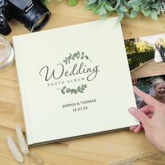 the wedding album is being held up by someone's hand with their thumb on it