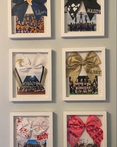 four framed pictures hanging on the wall with different designs and ribbons attached to each one