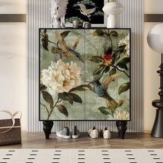 a cabinet with flowers and birds painted on the front, sitting in a living room