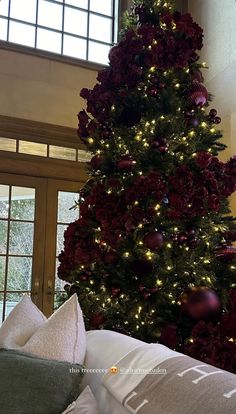 a large christmas tree is decorated with red and gold ornaments