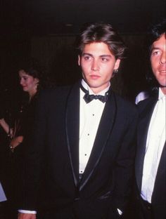 two men in tuxedos standing next to each other