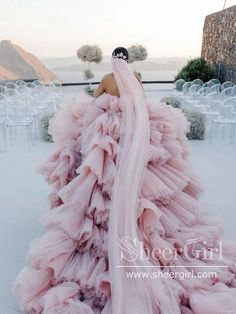 a woman in a long pink dress standing outside