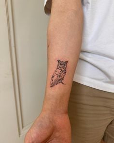 a small owl tattoo on the left inner arm and wrist is shown in black ink