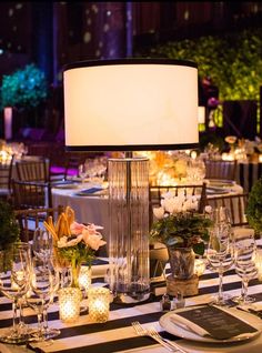 the table is set with candles, plates and silverware for an elegant dinner party