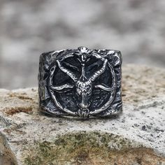 a silver ring with an image of a horned animal on it's face and two horns