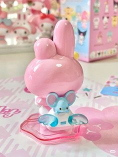 a pink and blue elephant figurine sitting on top of a table