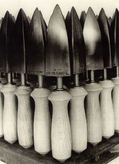 an assortment of wooden vases are lined up on a shelf in black and white