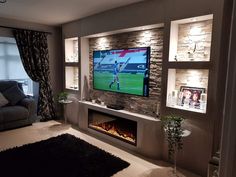 a living room filled with furniture and a flat screen tv mounted on the wall above a fireplace