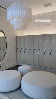 a room with several round stools and a chandelier hanging from the ceiling