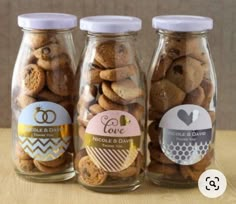 three jars filled with cookies sitting on top of a table