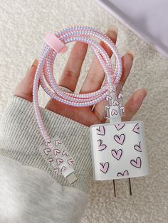 a person holding two bracelets with hearts on them and a tag attached to it