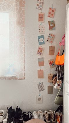 shoes are lined up on the floor in front of a wall with pictures and magnets