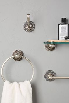 bathroom accessories displayed on gray wall with white towel