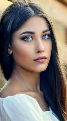 a beautiful young woman leaning against a wooden fence