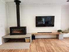 a living room with wood flooring and a flat screen tv mounted on the wall