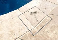 a pool with a tile floor next to it and a metal object on the ground