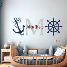 a child's room with a wall decal that says, name and ship wheel