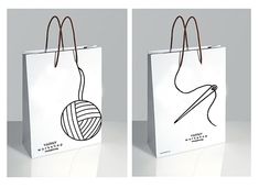 two white bags with black and white drawings on them, one has a ball of yarn in it