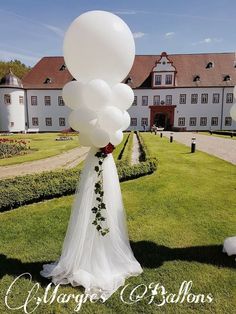 the bride is walking down the aisle with her bouquet in hand and balloons in the air