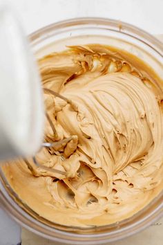 a mixing bowl filled with peanut butter on top of a counter