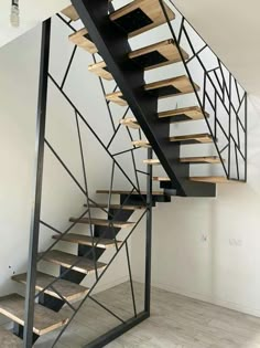 a metal staircase with wooden treads in an empty room