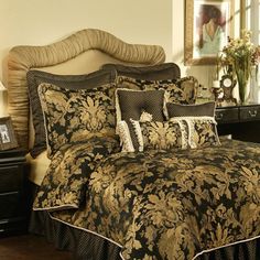 a bed with black and gold comforter in a bedroom