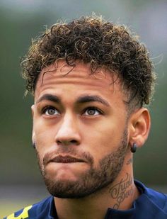 a close up of a man with tattoos on his neck and face looking at the camera