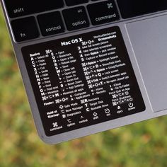 a close up of a person holding a laptop with stickers on the back of it