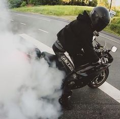 a man riding on the back of a motorcycle down a street