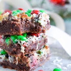 three pieces of christmas brownies stacked on top of each other with candy and sprinkles