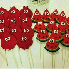 watermelon cake pops with googly eyes are on the table next to each other