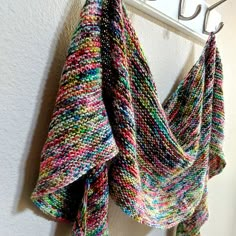 a multicolored knitted scarf hanging on a hook