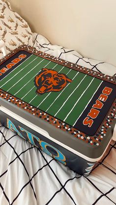 a cake in the shape of a chicago bears football field on top of a bed